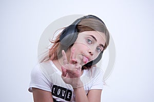 Girl listening a music on headphone Making a sign of peace and love