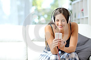 Girl listening music from smartphone at home