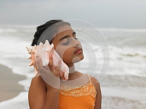 Girl listening to a conch photo