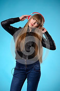 Girl listening to music with big red headphones