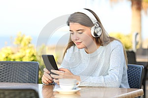 Girl is listening to music in a coffee shop terrace