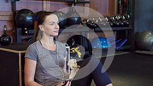 The girl is listening to music on headphones during a break between training sessions