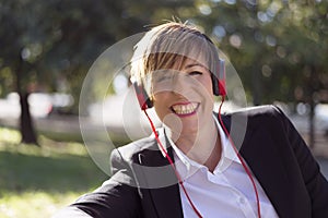 Girl listening to the music with headphones in a park