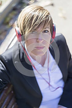 Girl listening to the music with headphones in a park