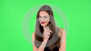 Girl listens carefully, threatens with a finger and waves her head seductively. Green screen