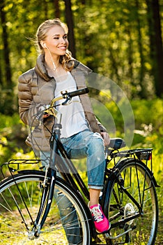 Girl listens music on a bicycle outdoors