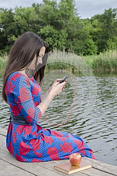 The girl listens to music outdoors