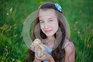 Girl with little yellow duckling in summer Park