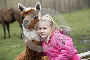Girl with a llama alpaca photo