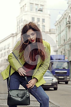 Girl with long brown hair walks around the city
