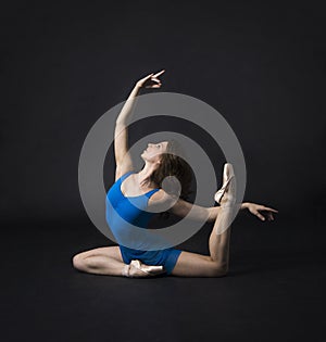 A girl with long hair, in a blue dress and Pointe shoes, dancing ballet