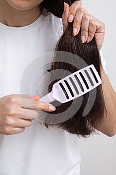 A girl with long hair combs her hair. Split ends and tangled hair concept