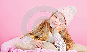 Girl long hair dream pink background. Kid dreamy wear knitted hat. Winter rest and relax. Winter season concept. Winter