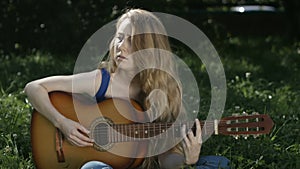 Girl with long hair learns to play guitar