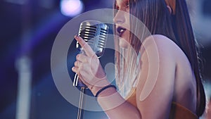 Girl with long hair sings to retro microphone