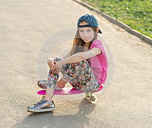 Girl with long hair sitting on skating board