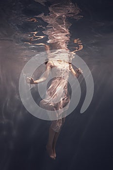 Girl with long hair swims underwater