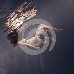 Girl with long hair swims underwater