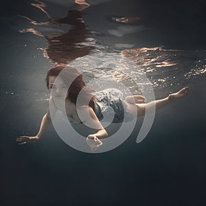 Girl with long hair swims underwater