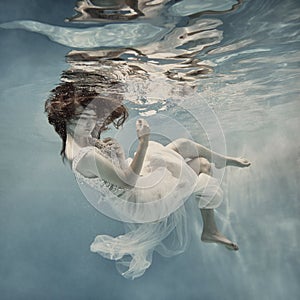 Girl with long hair swims underwater