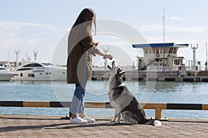 A girl with long hair treats the dog a treat