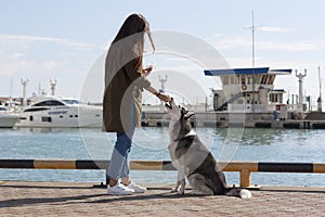 A girl with long hair treats the dog a treat