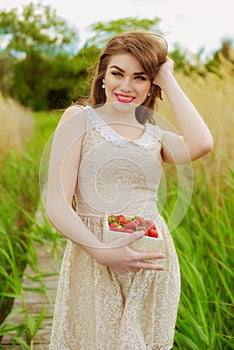 Girl with long hair in water in summer with strawberries