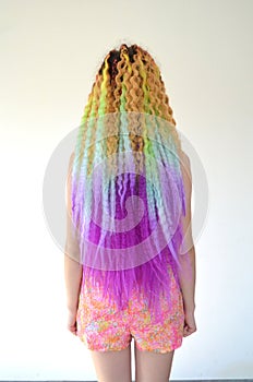 A girl with a long wavy hair painted in rainbow colors. Tunic hair kanekalon