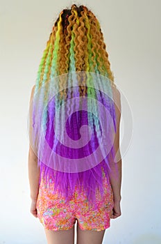 A girl with a long wavy hair painted in rainbow colors. Tunic hair kanekalon