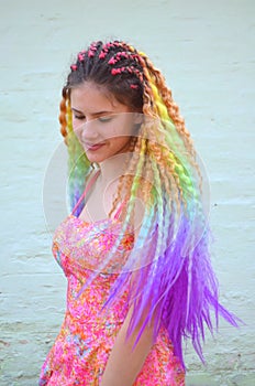 A girl with a long wavy hair painted in rainbow colors. Tunic hair kanekalon