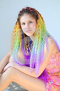 A girl with a long wavy hair painted in rainbow colors. Tunic hair kanekalon