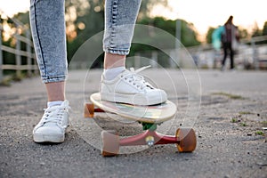 Girl with longboard wearing sneakers shoes in urban style