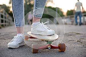 Girl with longboard wearing sneakers shoes in urban style