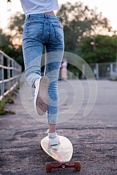 Girl with longboard wearing sneakers shoes in urban style