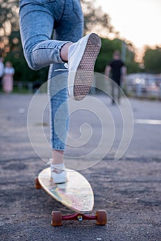 Girl with longboard wearing sneakers shoes in urban style