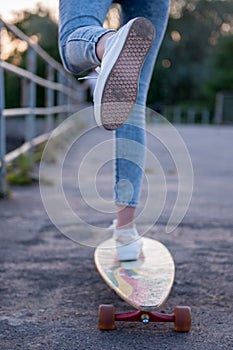 Girl with longboard wearing sneakers shoes in urban style