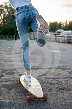 Girl with longboard wearing sneakers shoes in urban style