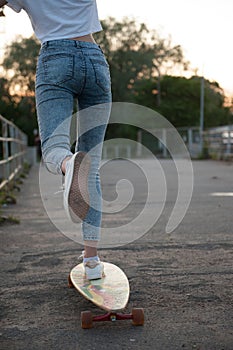 Girl with longboard wearing sneakers shoes in urban style