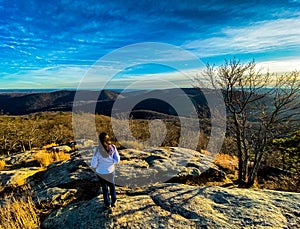 Girl looking beyond on top of the hill in a beautiful autumn afternoon