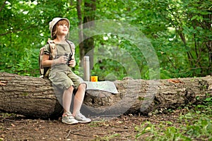 Girl looking birds through binoculars, camping in the woods