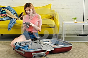 girl looking at camera while packing suitcase