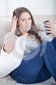 Girl looking at cellphone worried expression