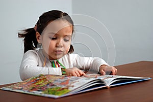 Girl looking in a colorful story book