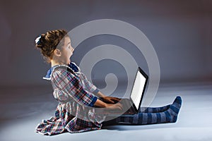 Girl looking computer on a gray background