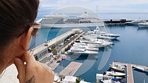 Girl looking at cruise liner from hotel terrace, waiting for embarkation on ship