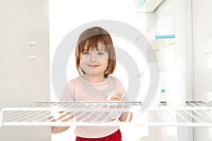 Girl looking in empty fridge