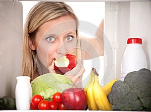 Girl looking at food in fridge