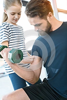 Girl looking at guy workout with dumbbell