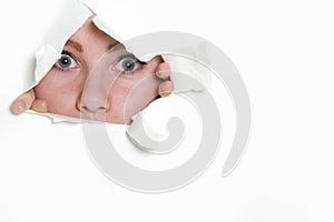 Girl looking through hole in paper