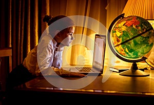 Girl looking at laptop screen at dark room